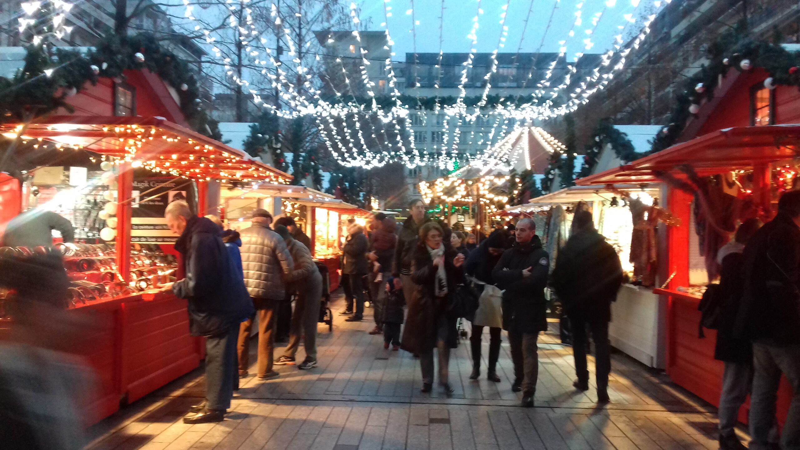 Promenade dans les allées du Marché de Noël chalet associatif Les passants se promènent entre les chalets du marché de noël de Boulogne Billancourt chalet associatif