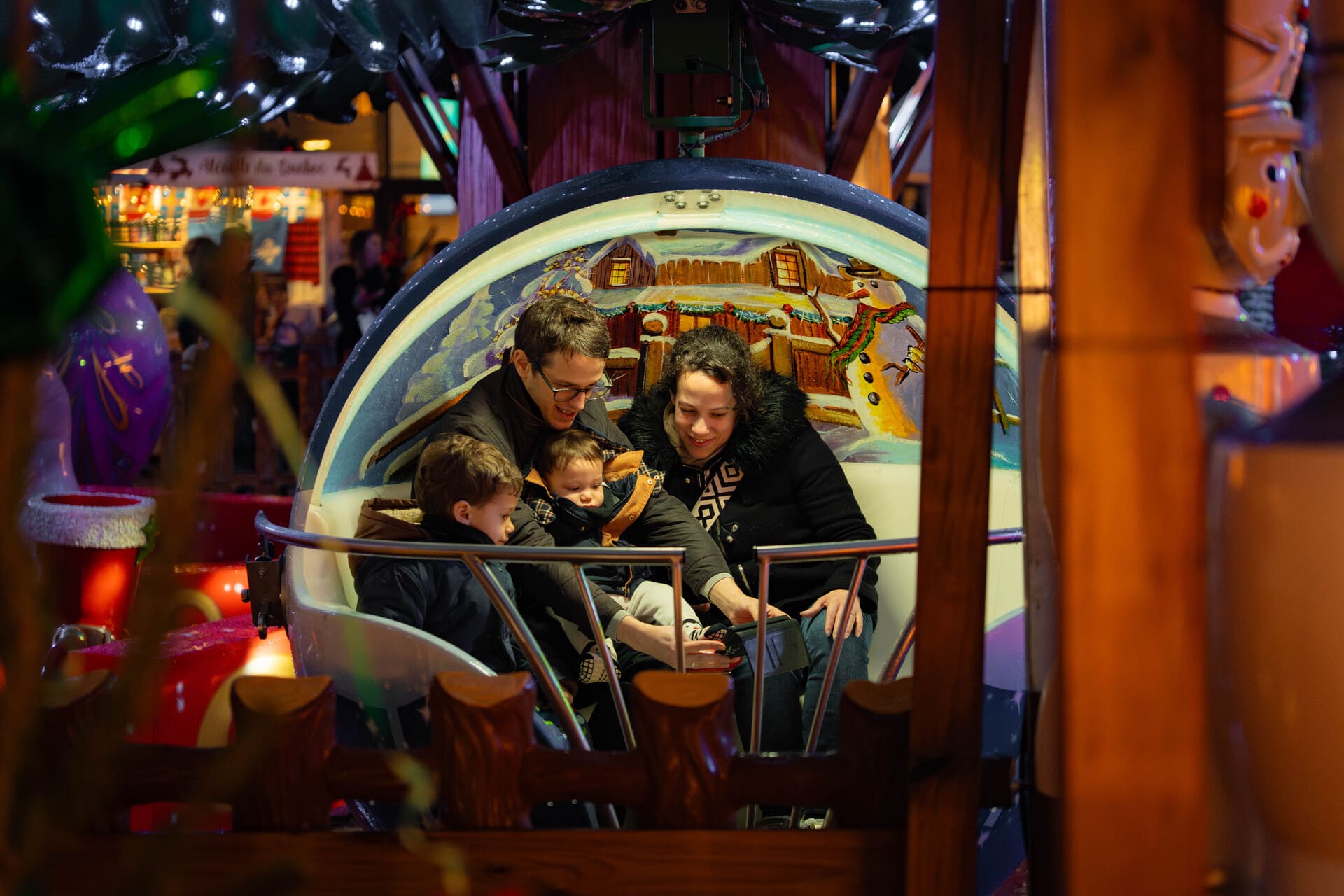 Famille dans un manège sur marché de Noël